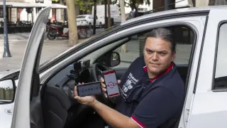 El taxista Héctor Milán muestra desde su coche la aplicación móvil MoZa.