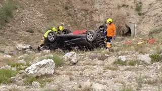 El coche ha quedado volcado tras caer por el terraplén.