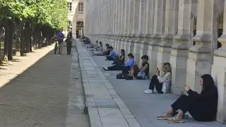 En la imagen, un grupo de personas se refugia del calor este lunes en las inmediaciones del jardín del Palacio Real de París.
