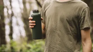 hombre-sujetando-botella-agua-naturaleza
