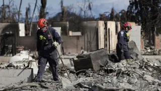 Miembros del Equipo de Búsqueda y Rescate Urbano de la Agencia Federal para el Manejo de Emergencias que recorren una zona destruida por los incendios en Lahaina, Hawai (EE.UU.).
