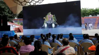 Varias personas miran en directo el alunizaje de la sonda en el polo sur de la India.