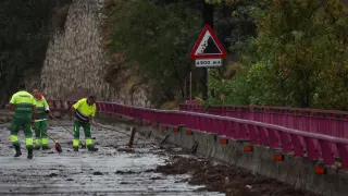 Los trabajadores retiran escombros de un puente, tras inundaciones y fuertes lluvias en Toledo.