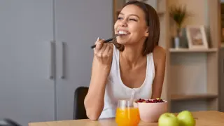 Una mujer comiendo fruta.