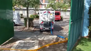Un camión carga agua de las piscinas de verano de la Ciudada Deportiva de Huesca para limpieza viaria.