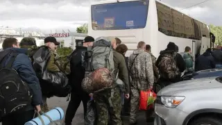 Varios hombres suben a un autobús en una oficina de reclutamiento durante la movilización militar parcial de Rusia