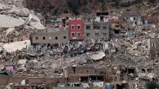 Varias personas entre los escombros en la aldea de Imi N'Tala, que fue devastada por el devastador terremoto en Marruecos.