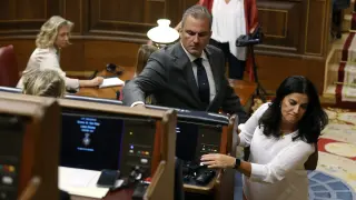 El diputado de Vox Francisco Ortega Smith deposita su pinganillo en el escaño de Pedro Sánchez en el primer día de uso de lenguas cooficiales en el Congreso