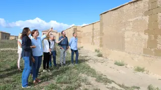 En primer plano, la vicepresidenta segunda de la DPH, Celsa Rufas, junto a los técnicos, frente al recién rehabilitado muro perimetral.