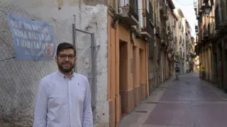 Armando Martínez junto a un cartel colocado en el barrio del Gancho que reivindica su rehabilitación.