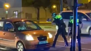 Fotograma de uno de los vídeos que se han difundido por redes sociales en el que se puede ver a unos de los agentes apuntando con un arma al vehículo.