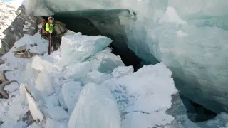 El geólogo José Luis Piedrafita en la caverna formada por un conducto subglaciar de desagüe con grandes bloques de hielo caídos.