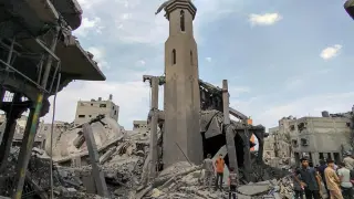 Palestinos inspeccionan los daños tras un ataque aéreo israelí contra la mezquita de Sousi en la ciudad de Gaza.