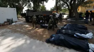 Soldados recogen a los fallecidos en el kibutz de Kfar Aza.