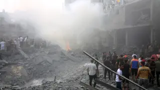 Ciudadanos palestinos buscan entre los escombros de los edificios destruidos tras un ataque israelí, en la ciudad de Rafah, en la Franja de Gaza.