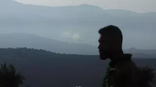 Un hombre observa el fuego cruzado entre el Ejército israelí y Hezbolá en la frontera entre Israel y Líbano