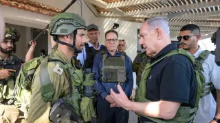 HANDOUT - 14 October 2023, Israel, Kibbutz Beeri: Israels Prime Minister Benjamin Netanyahu (L) speaks to a member of the IDF during his visit to Kibbutz Beeri and Kibbutz Kfar Aza. Photo: Avi Ohayon/GPO/dpa - ATTENTION: