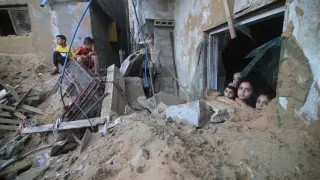 Niños palestinos en ruinas de edificios destrozados en Gaza