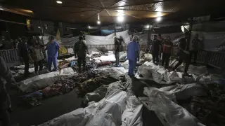Los cuerpos de los palestinos muertos por una explosión en el hospital árabe Ahli se reúnen en el patio delantero del hospital al-Shifa, en la ciudad de Gaza.