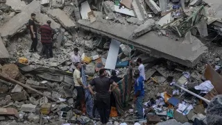 La gente se encuentra entre los escombros de la iglesia ortodoxa griega de San Porfirio tras un ataque aéreo nocturno en Gaza.