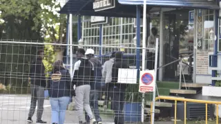 Migrantes atendidos por una trabajadora de la ong Apip-Acam a las puertas del Hotel Montearagón de Huesca.