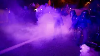La policía antidisturbios española lanza gases lacrimógenos durante una protesta cerca de la sede del Partido Socialista de España (PSOE)