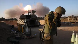Un soldado israelí cubre su oídos ante un disparo de artillería de un tanque en la frontera de la Franja de Gaza MIDEAST ISRAEL PALESTINIANS GAZA CONFLICT