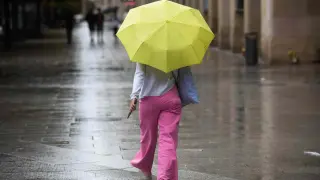 Una mujer bajo la lluvia en el paseo de la Independencia de Zaragoza.