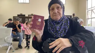 Una mujer muestra su pasaporte español mientras espera a poder salir de Gaza
