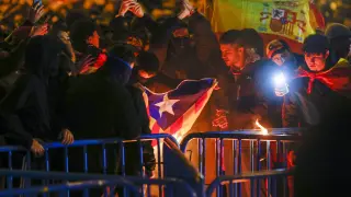 Manifestantes queman una estelada durante la protesta convocada contra la amnistía y el Gobierno de Pedro Sánchez, investido como presidente hoy jueves, en las inmediaciones de la sede del PSOE, en la madrileña calle de Ferraz.