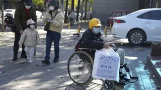A child in a wheelchair holds up a bag from a children's hospital radiology department in Beijing, Friday, Nov. 24, 2023. Chinese officials say they did not detect any "unusual or novel diseases" in the country, the World Health Organization said Thursday, following an official request by the U.N. health agency for information about a potentially worrying spike in respiratory illnesses and clusters of pneumonia in children. (AP Photo/Ng Han Guan)