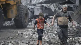 Los palestinos se abren paso entre los escombros tras los ataques aéreos israelíes contra Deir Al Balah, en el sur de la Franja de Gaza