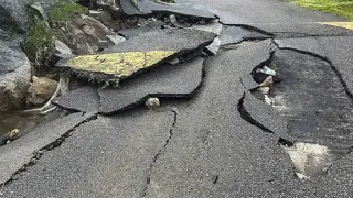 Cracks along a road in the aftermath of a massive explosion at an industrial area on the main island in Mahe, Seychelles, Thursday, Dec. 7, 2023. Authorities in Seychelles declared a state of emergency Thursday after a blast at an explosives store caused “massive damage” in an industrial area also facing flooding amid heavy rainfall, according to the presidency. The blast happened on Wednesday night in the Providence area of Mahe, the largest and most populous island of the Seychelles. (AP Photo/Emilie Chetty)