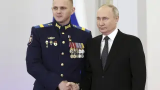 El presidente ruso, Vladimir Putin, posa con el sargento Alexander Mikhailov durante una ceremonia para presentar las medallas de la Estrella de Oro a los Héroes de Rusia