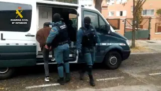 Guardias civiles introducen a uno de los detenidos en un furgón del Cuerpo.