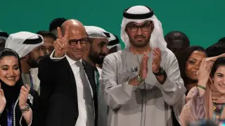 El jefe climático de las Naciones Unidas, Simon Stiell y el presidente de la COP28, Sultan al-Jaber, posan para fotografías al final de la Cumbre Climática de la ONU COP28