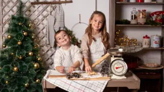 Una pareja de niños hacen un pastel en una sesión de fotos de Navidad.