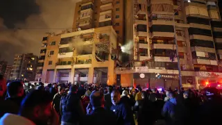 People gather outside a damaged building following a massive explosion in the southern Beirut suburb of Dahiyeh, Lebanon, Tuesday, Jan. 2, 2024. An explosion killed Saleh Arouri, a top official with the Palestinian militant group Hamas and three others, officials with Hamas and the Lebanese group Hezbollah said. (AP Photo/Bilal Hussein)