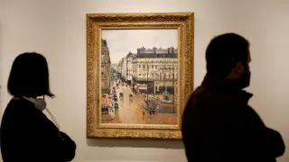 Dos personas contemplan la obra 'Rue Saint-Honoré, après midi, effet de pluie', de Pissarro, en el Thyssen de Madrid.