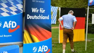 FILE PHOTO: A supporter of the Alternative for Germany (AfD) walks past AfD banners at the Gillamoos Fair