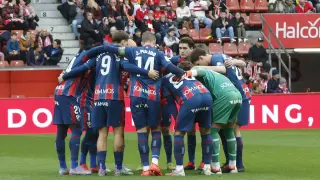 Los jugadores de la SD Huesca se reúnen antes del inicio del partido con el Sporting.