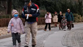 Una familia, de paseo por un parque de Pekín