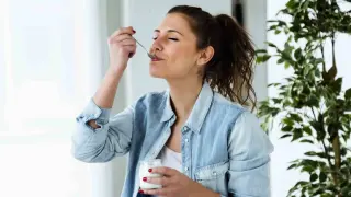 Una mujer comiendo un yogur. gsc1