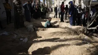 Los palestinos cavan tumbas para enterrar a sus familiares que murieron en el bombardeo israelí de la Franja de Gaza, en el hospital Nasser en Khan Younis, en el sur de la Franja de Gaza