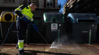 Un trabajador de FCC, junto a un contenedor con la campaña de limpieza que ha desplegado el Ayuntamiento.