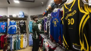 Carlos Martínez, ordenando algunas de las camisetas de Basket World.