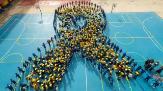 Alumnos de primaria del colegio Santo Domingo de Silos de Zaragoza han formado un lazo dorado, símbolo internacional de la lucha contra el cáncer infantil.