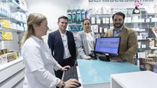 Alberto Gómez, cofundador de Media Value (a la derecha, con americana marrón), en una farmacia.