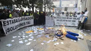 Los manifestantes encienden una hoguera ayer frente a la Delegación del Gobierno en Aragón.