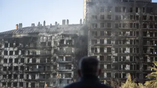 Un hombre observa la estructura del edificio tras el incendio de Valencia